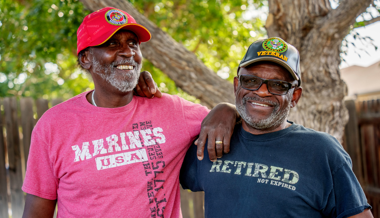 Two men with veteran hats smiling 