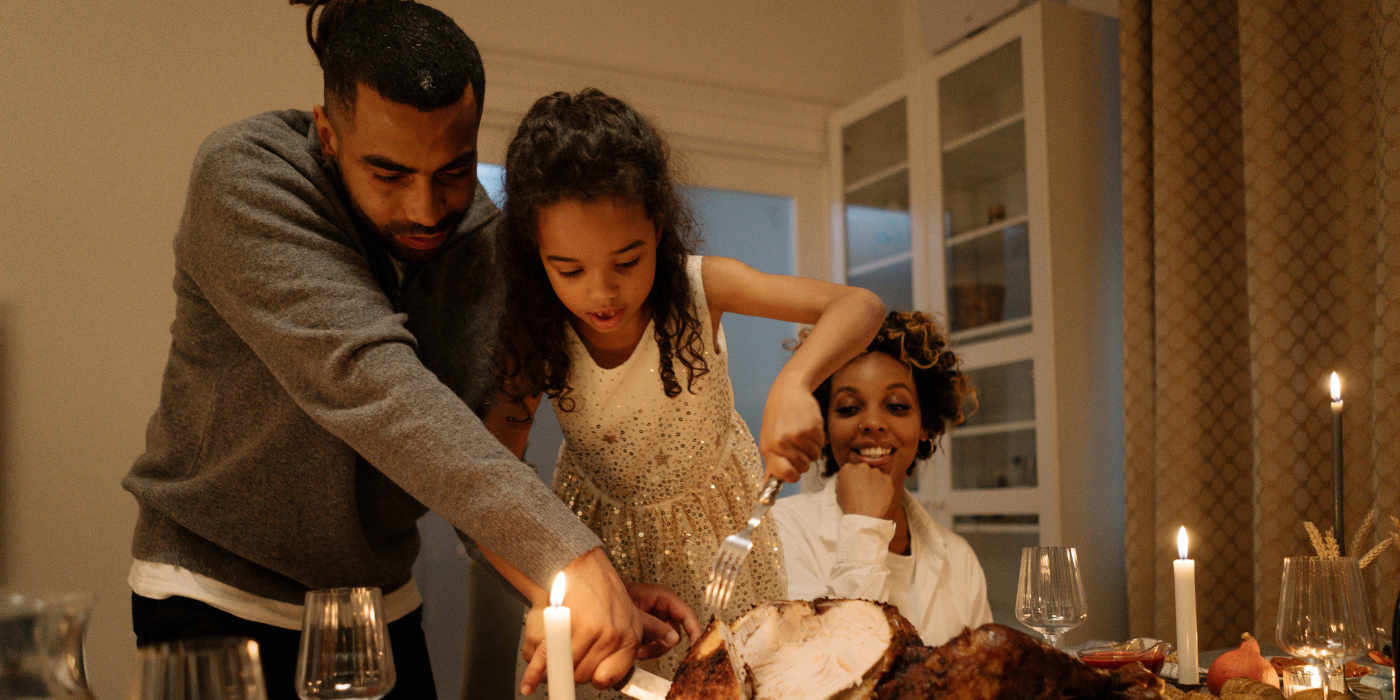family cutting thanksgiving dinner
