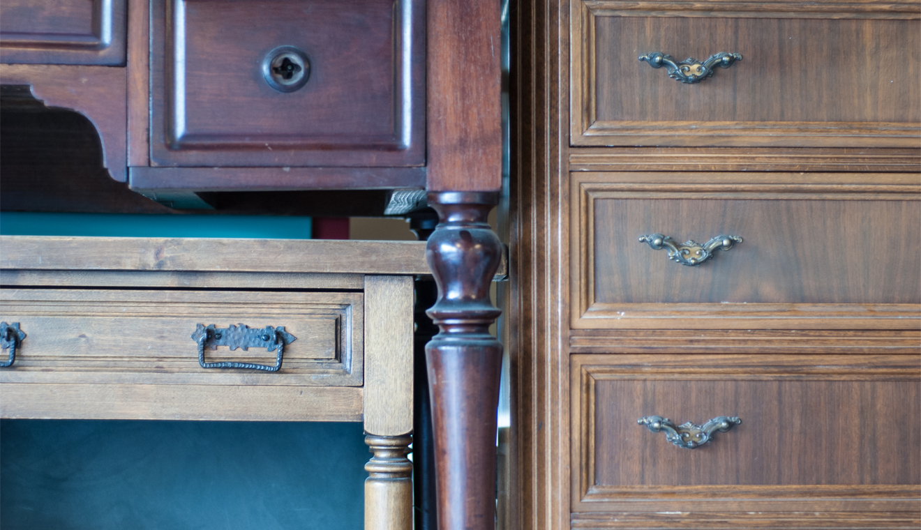 Wood furniture with drawers and decorative metal handles.
