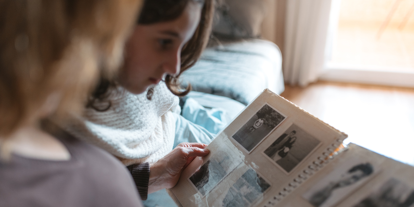 Person looking through a photo album while sitting indoors