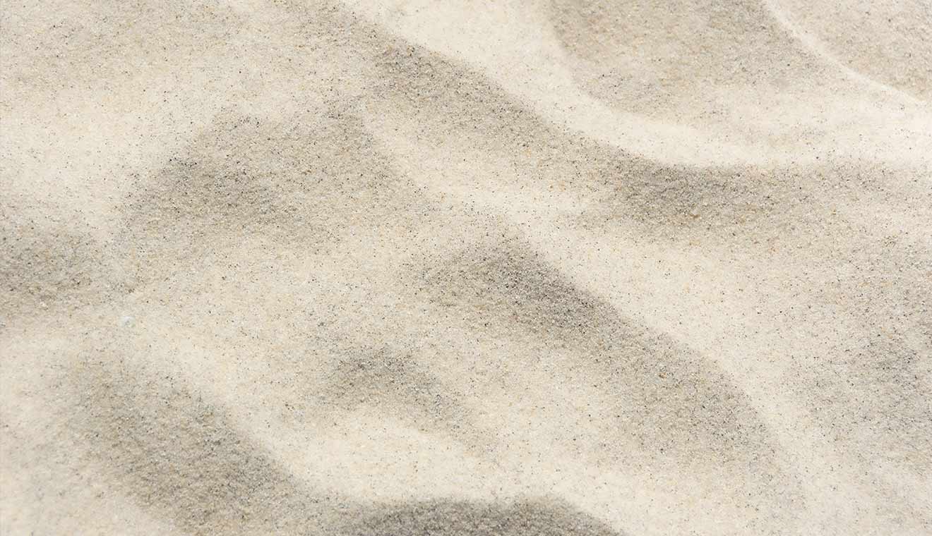Minimal textured sand surface with soft natural contours and shadows
