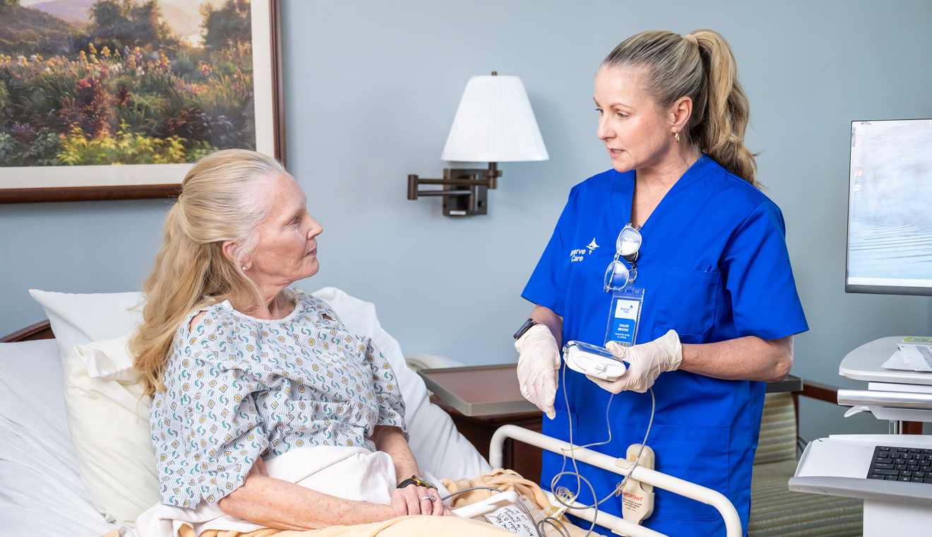 female nurse standing at beside of female patient