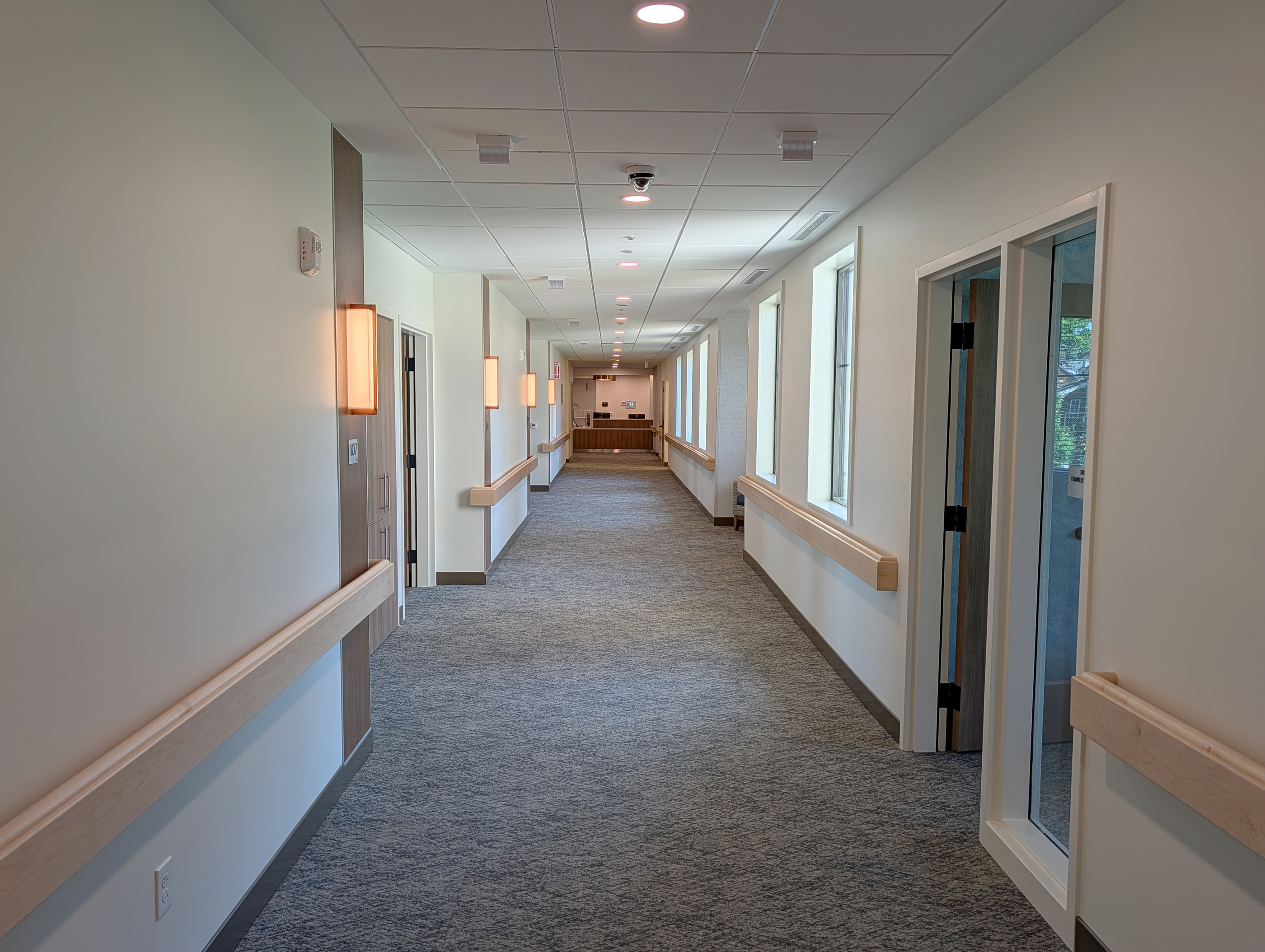 A Care Center Cleveland hallway showing room doors and lighting sconces