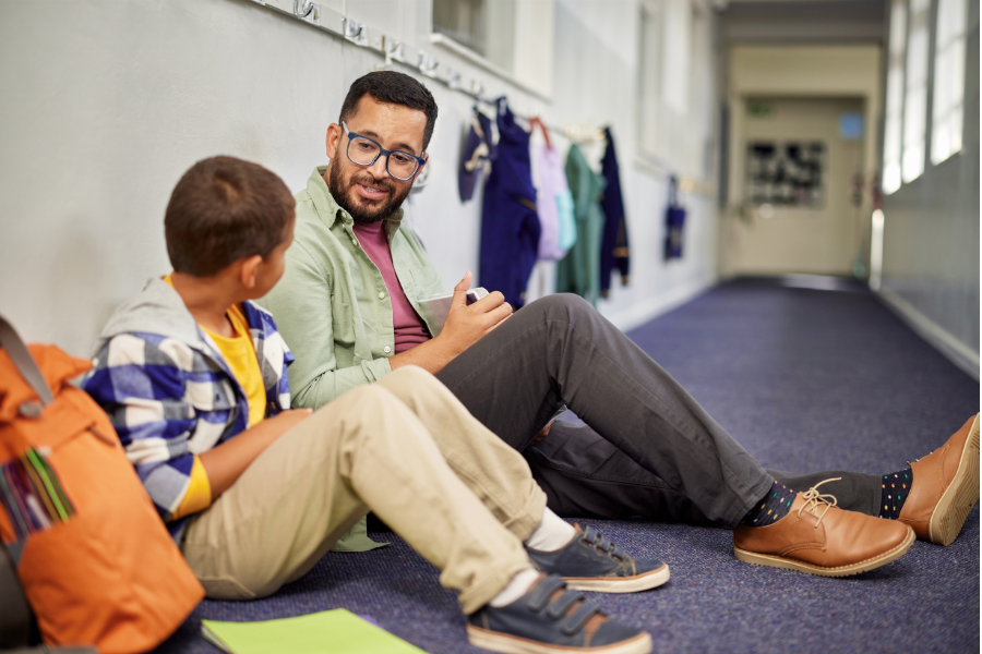 Man talking to child at school