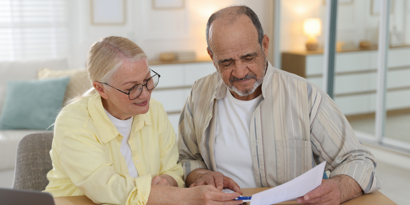 Man and women looking at paperwork and computer