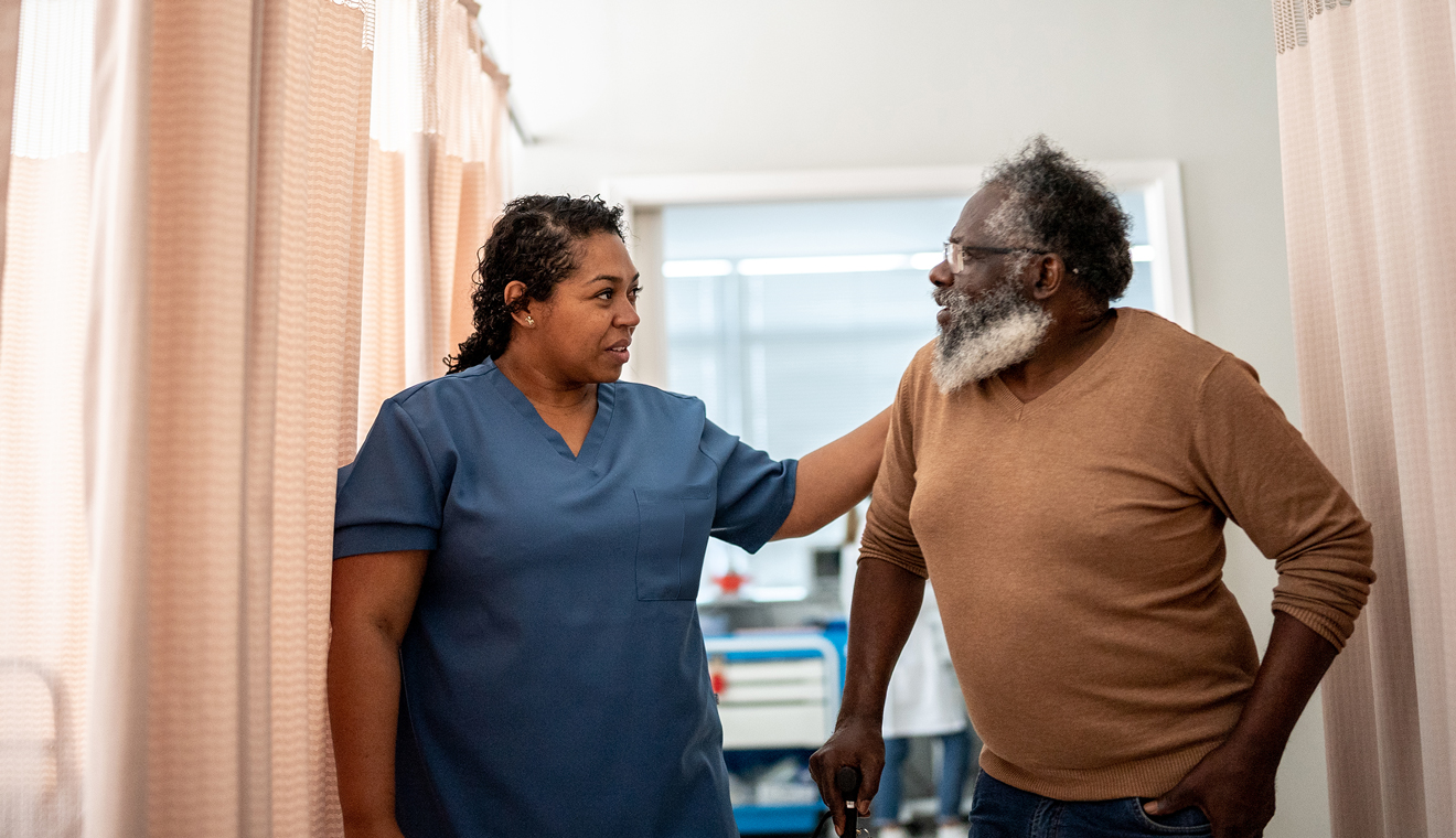 Woman in scrubs talking to man