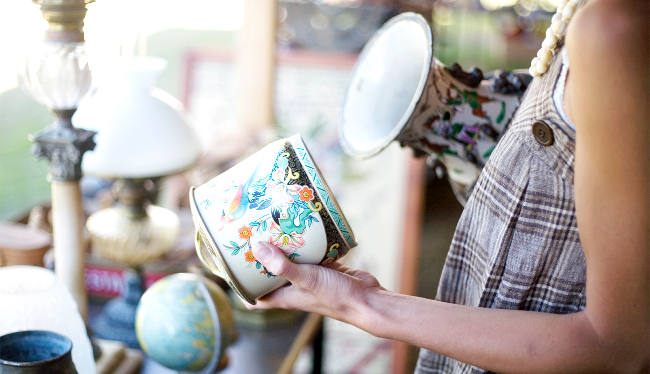 Person holding decorative dishes while shopping in a store